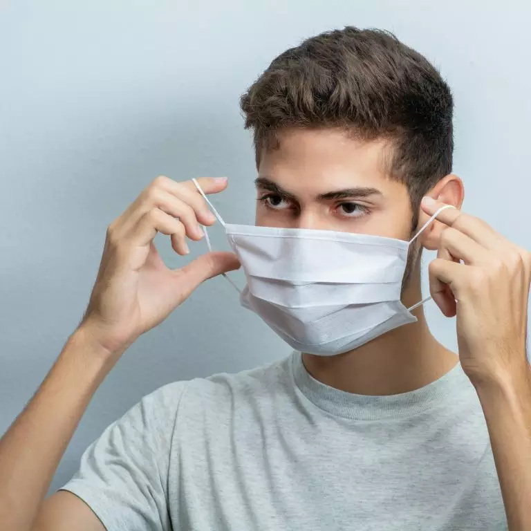 a man putting on a face mask